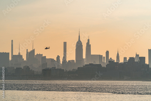 Vivid Manhattan skyline morning sunrise with helicopter flaying across the buildings  travel tourism theme USA city  world famous destination. Horizontal photograph.