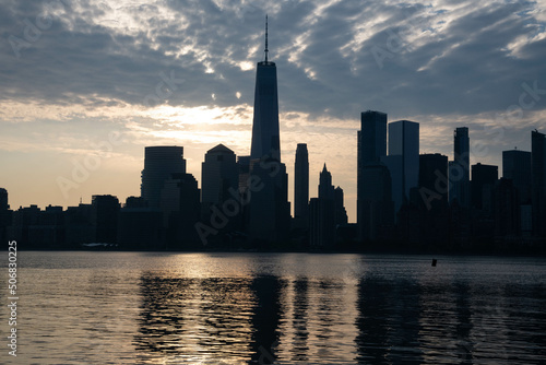 NYC Manhattan skyline in silhouette during sunrise   travel theme  vivid textured city life photograph. Wide angle perspective horizontal.
