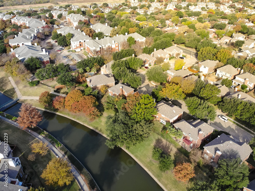 Aerial view riverside two story houses and apartment complex surrounded by colorful fall foliage near Dallas, Texas, America