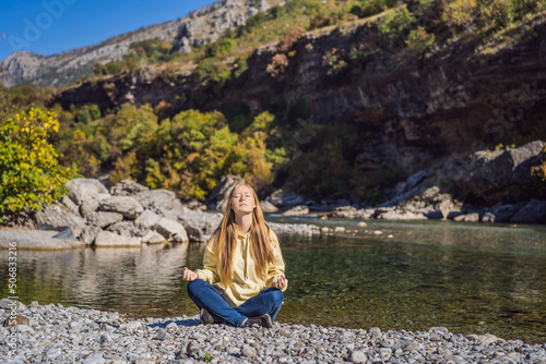Montenegro. Woman tourist meditates on the background of Clean clear turquoise water of river Moraca in green moraca canyon nature landscape. Travel around Montenegro concept