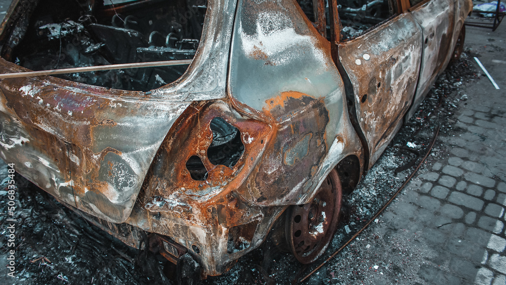 Irpin, Kyiv Oblast, Ukraine - 19.05.2022: Cities of Ukraine after the Russian occupation. burnt civilian car in city of Irpin, northwest of Kyiv