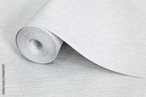 a rolled-out roll of vinyl wallpaper lying on the floor