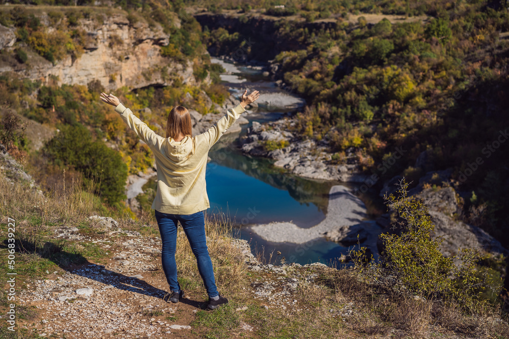 Montenegro. Woman tourist on the background of Clean clear turquoise water of river Moraca in green moraca canyon nature landscape. Travel around Montenegro concept Montenegro. Woman tourist on the background of Clean clear turquoise water of river Moraca in green moraca canyon nature landscape. Travel around Montenegro concept