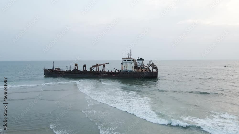 Aerial view of old abandoned wreck ship on shoreline of coastline during cloudy day Aerial view of old abandoned wreck ship on shoreline of coastline during cloudy day