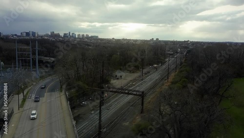 Railroad Track Underneath Highway Bridge Full Of Cars, Drone Tracking Shot. Philadelphia, Pennsylvania, USA.
