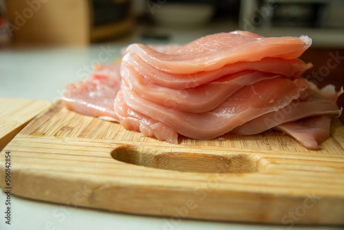 Sliced raw pork loin lying on a wooden board