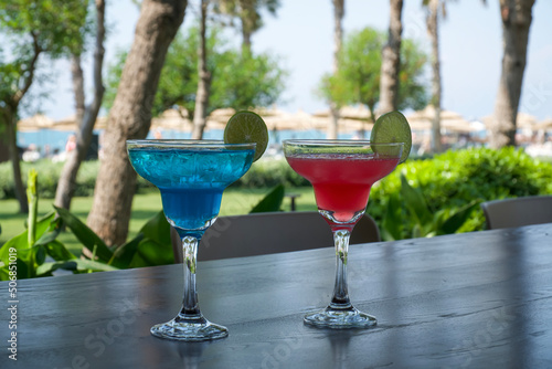 Cocktails on terrace. Red and blue cocktail on a wooden table in a cafe, on vacation