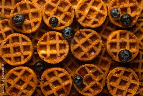 Soft round fried waffles on a beige background. Monochrome pattern with hard shadows. photo