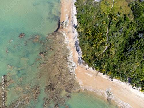 Amazing paradisiacal and deserted beach with clear blue waters and visible corals at low tide - Cumuruxatiba, Bahia, Brazil - aerial drone view