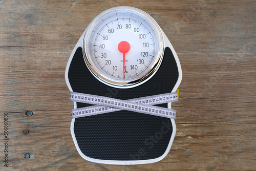 floor mechanical scales in vintage style, scale with red arrow in circle, centimeter measuring tape, top view, the concept of weight control, human physical health, diet and nutrition, lose weight