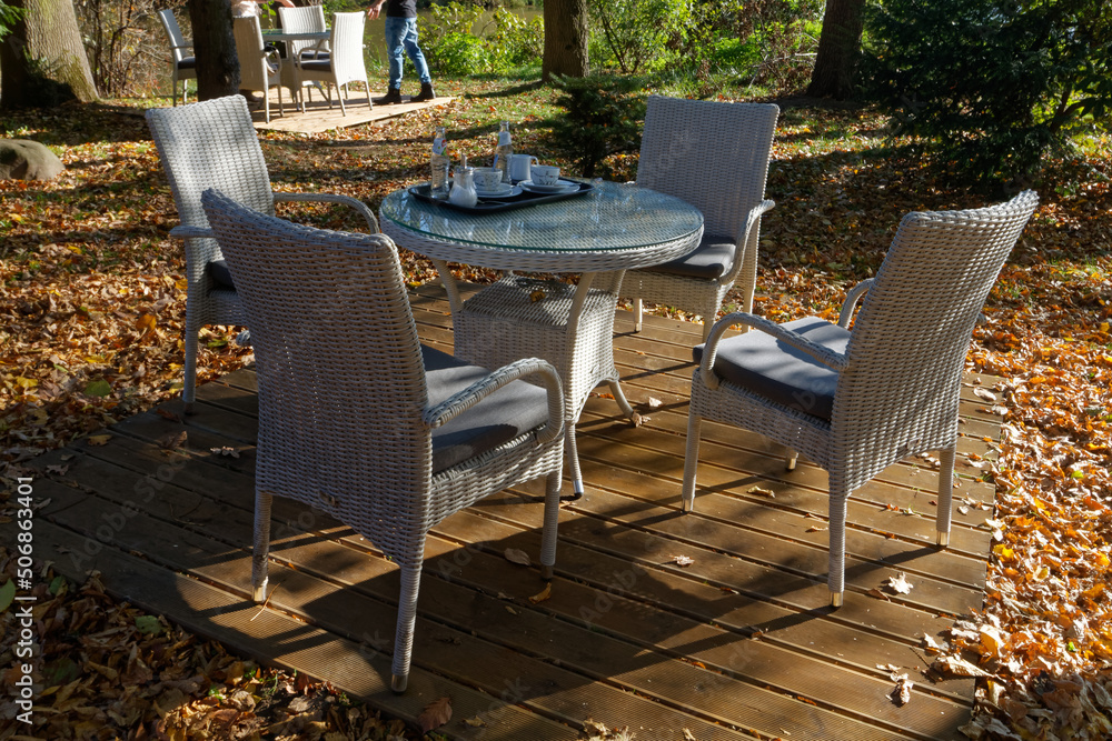 Naklejka premium Kawiarniany stolik z krzesłami w parku