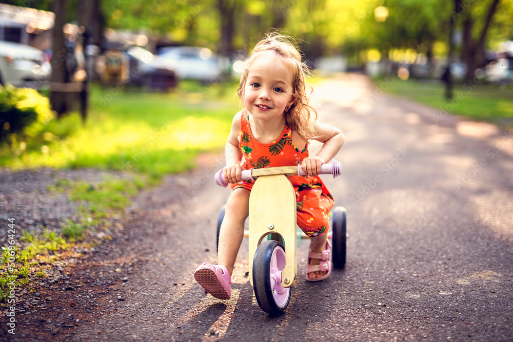 happy child girl rides a racetrack in Park in the summer sunset happy child girl rides a racetrack in Park in the summer sunset