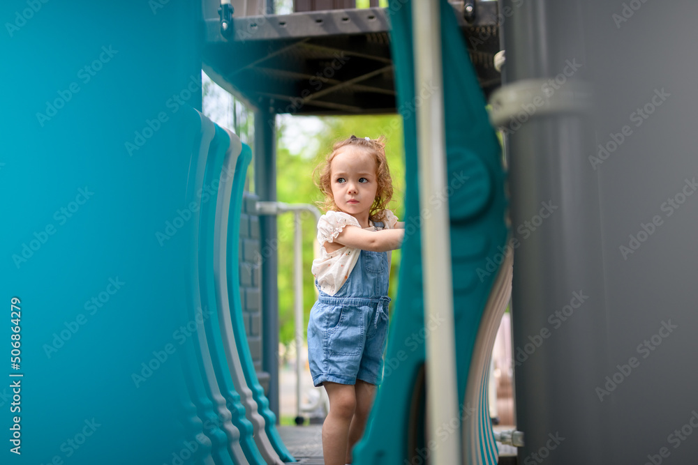 Child playing on outdoor playground. Active kid on playground summer activity for children Child playing on outdoor playground. Active kid on playground summer activity for children
