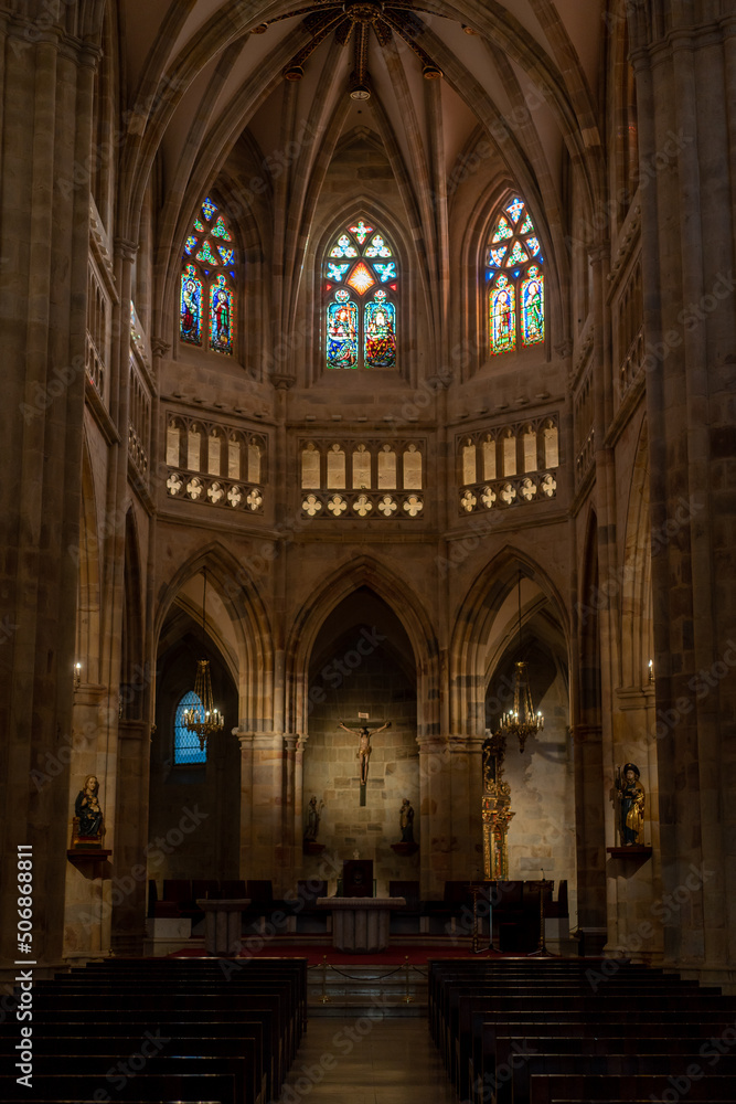 interior view of the cathedral of Bilbao in Spain, with its stained glass windows, altar and pews.