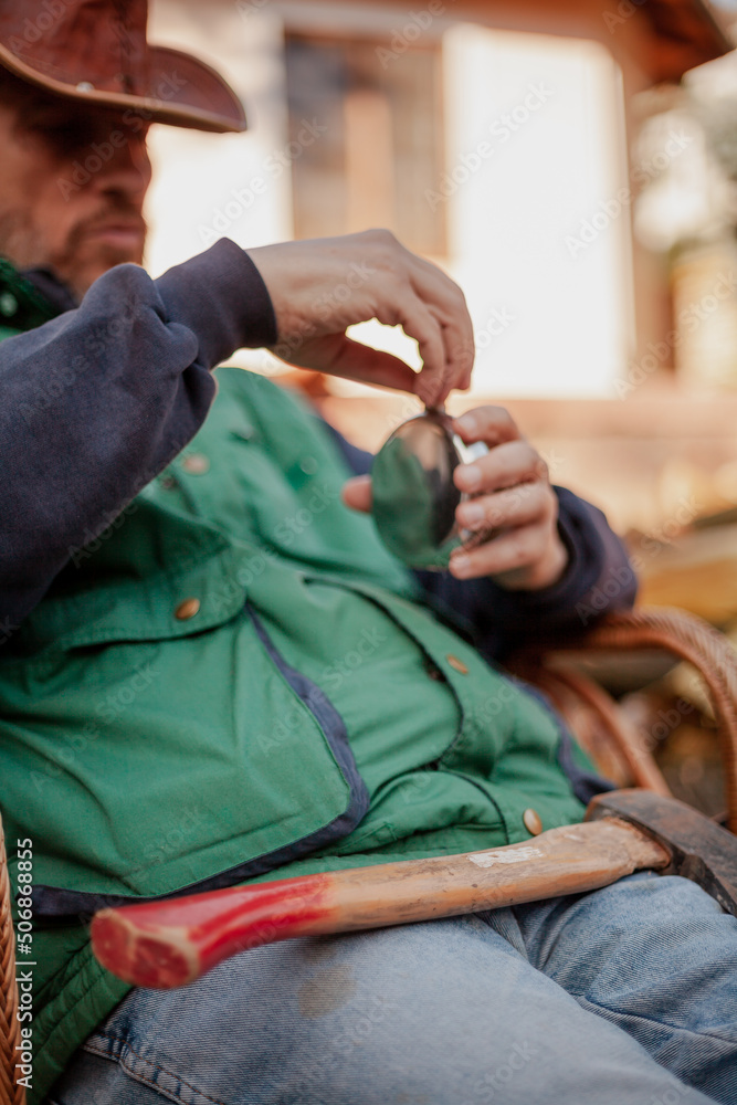 Fototapeta premium Man sits in chair and opens flask