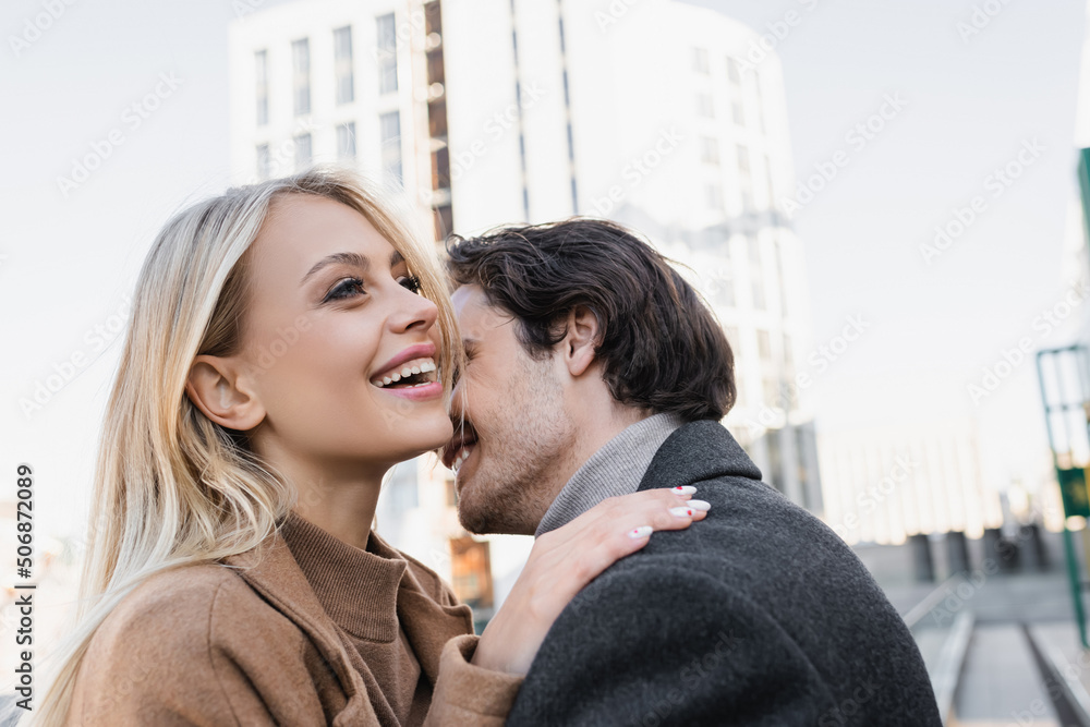 cheerful blonde woman touching shoulder of young man outdoors. cheerful blonde woman touching shoulder of young man outdoors.