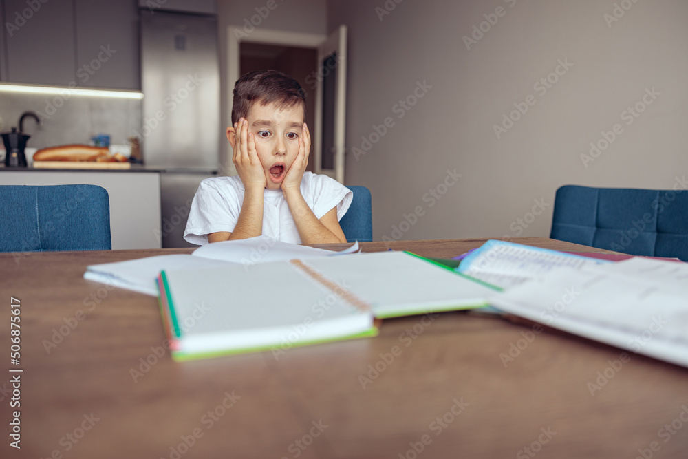 Portarit of cute small teen schoolboy looking shocked and surprised because of homework. Portarit of cute small teen schoolboy looking shocked and surprised because of homework.