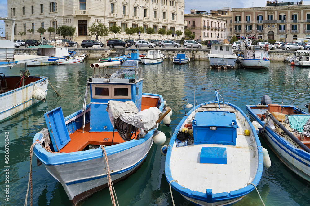 Sicily, Italy - April 13, 2022: Sea coast with moored boats and fishing boats. Fishing village.