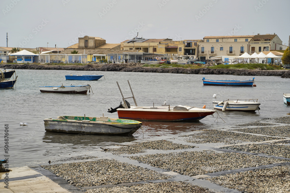 Sicily, Italy - April 16, 2022: Sea coast with moored boats and fishing boats. Fishing village.