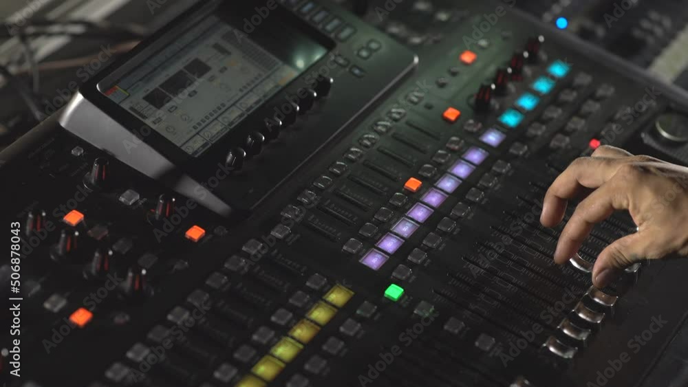 Hand pushing butons in mixing console Hand pushing butons in mixing console