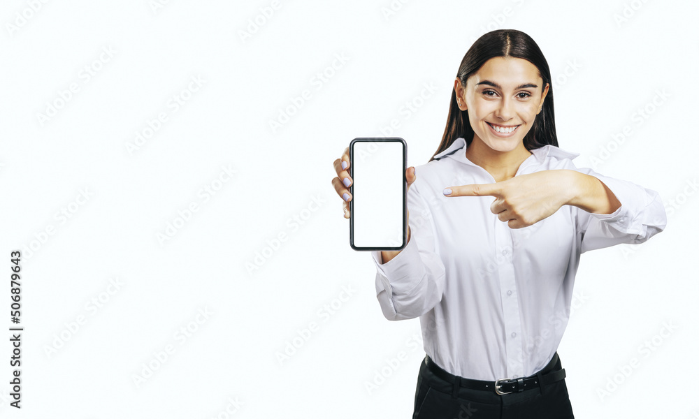 Mobile application concept with happy girl in white shirt showing modern smartphone with white blank screen on abstract light background with place for your logo or text, mock up Mobile application concept with happy girl in white shirt showing modern smartphone with white blank screen on abstract light background with place for your logo or text, mock up