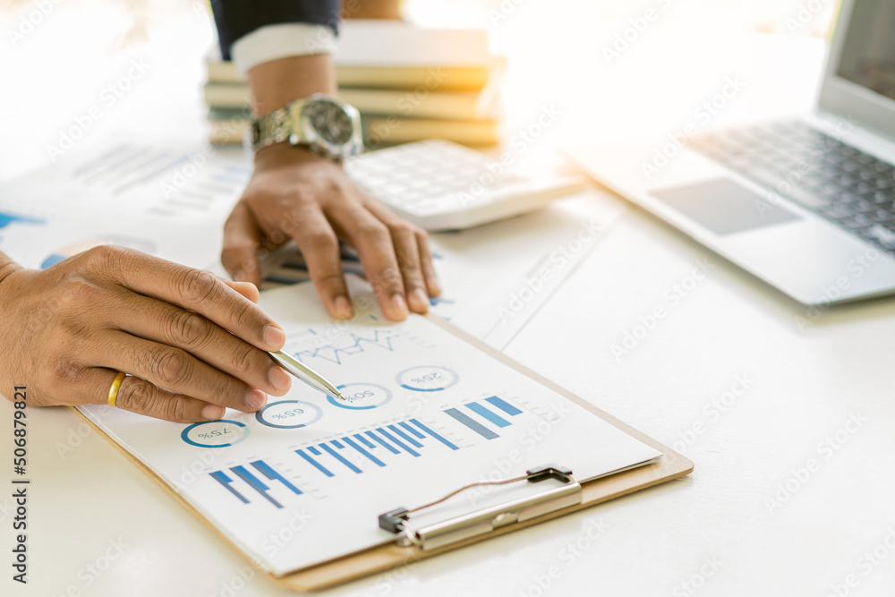 Close-up of businessman holding pen pointing to graph graph in document Corporate financial marketing, research, development, planning, management, strategy, analysis, business office concept. Close-up of businessman holding pen pointing to graph graph in document Corporate financial marketing, research, development, planning, management, strategy, analysis, business office concept.