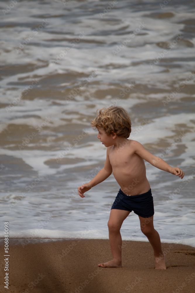 Fototapeta premium MENINO LOIRO BRINCANDO NA PRAIA 
