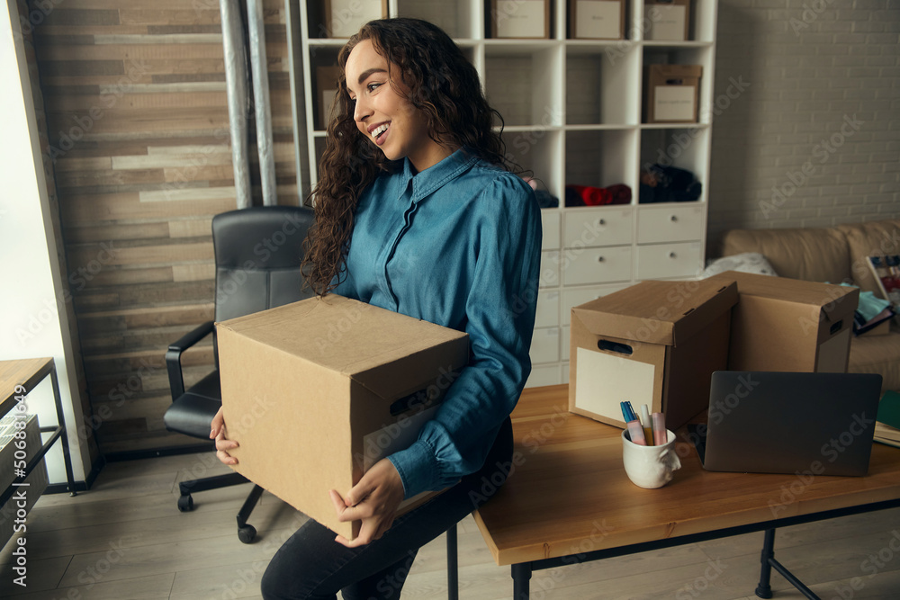 A young woman sits on the windowsill in front of the boxes and fills out a diary, collects parcels for the post office. entrepreneur online store A young woman sits on the windowsill in front of the boxes and fills out a diary, collects parcels for the post office. entrepreneur online store
