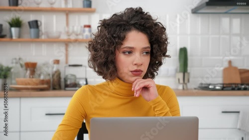 Thoughtful businesswoman looking away thinks about solving problem unprofitability of company in times of crisis. Pensive woman top manager distance works for laptop computer sitting on couch at home photo