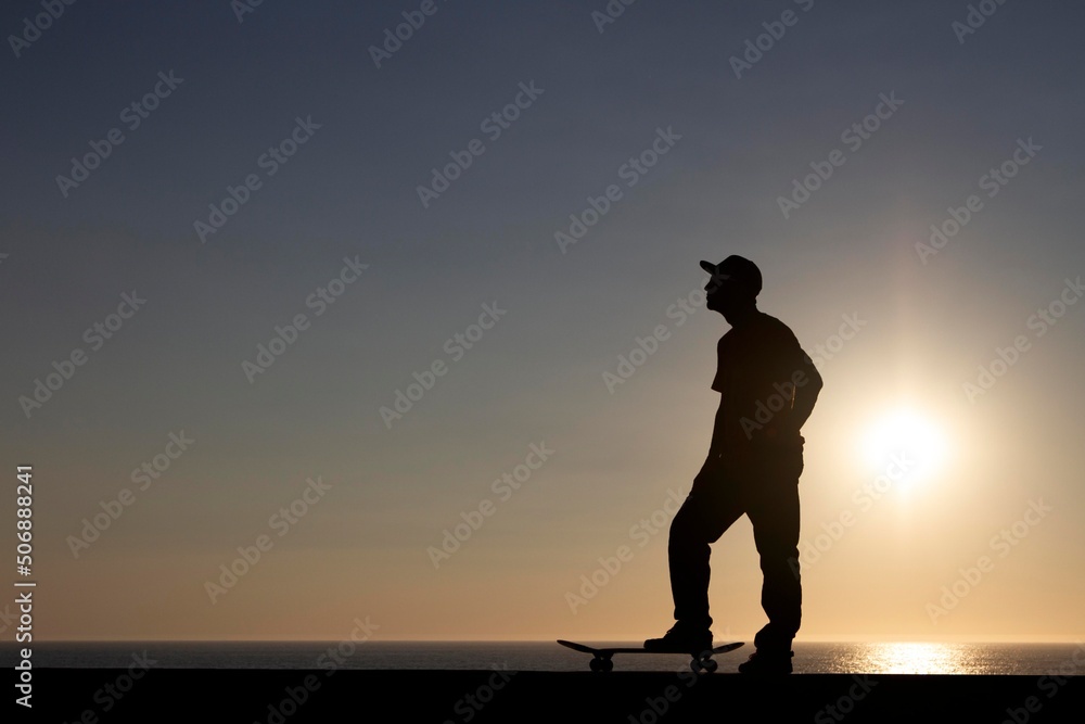 summer skateboarder silhouette with board on the ground