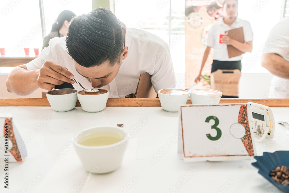 Professional cupper examining and tasting a coffee with a metal spoon in Matagalpa Nicaragua Professional cupper examining and tasting a coffee with a metal spoon in Matagalpa Nicaragua