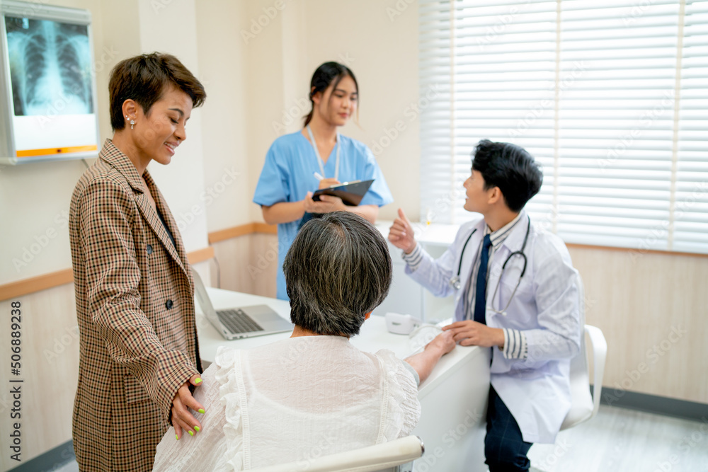 Obraz premium Back of senior woman discuss with young doctor analysis the disease and her relative stay beside with grandchild and daughter in consulting room of hospital.