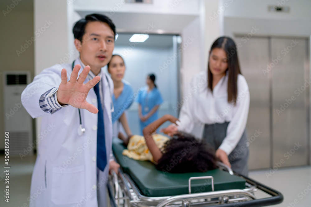 Obraz premium Close up and main focus of doctor hand express to request to clear the way for emergency patient bed after out from elevator in hospital.
