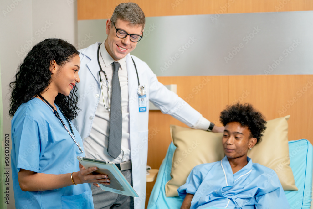 Nurse hold tablet and also explain the treatment result to patient who lie on bed and he look happy after know good result. Nurse hold tablet and also explain the treatment result to patient who lie on bed and he look happy after know good result.