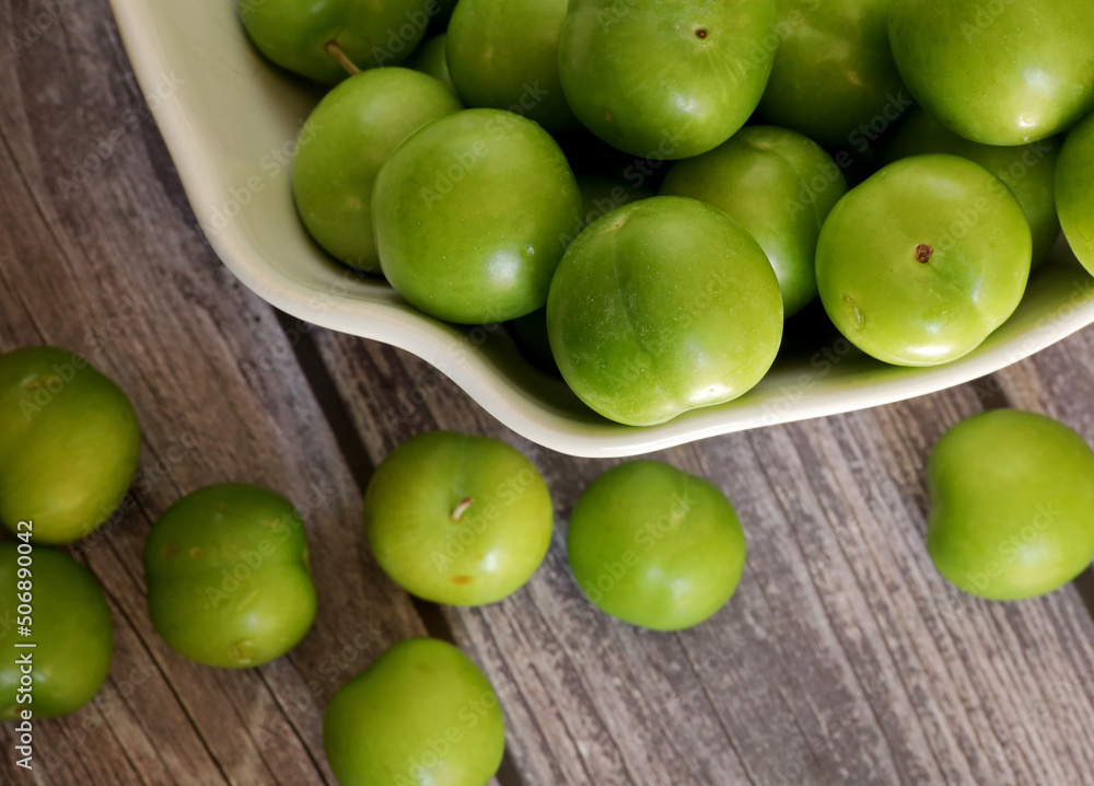 green plums on the wooden table green plums on the wooden table