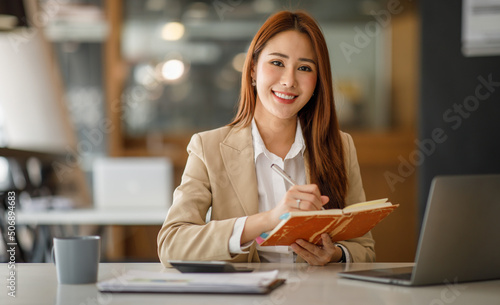 Asian businesswoman working happily about the success of the company,doing planning analyzing the financial report, business plan investment, finance analysis concept.