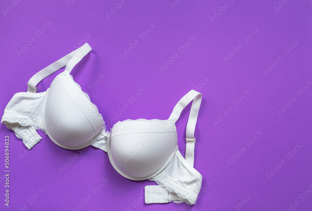 Foto de White new bra on a violet background. Bra, lace lingerie