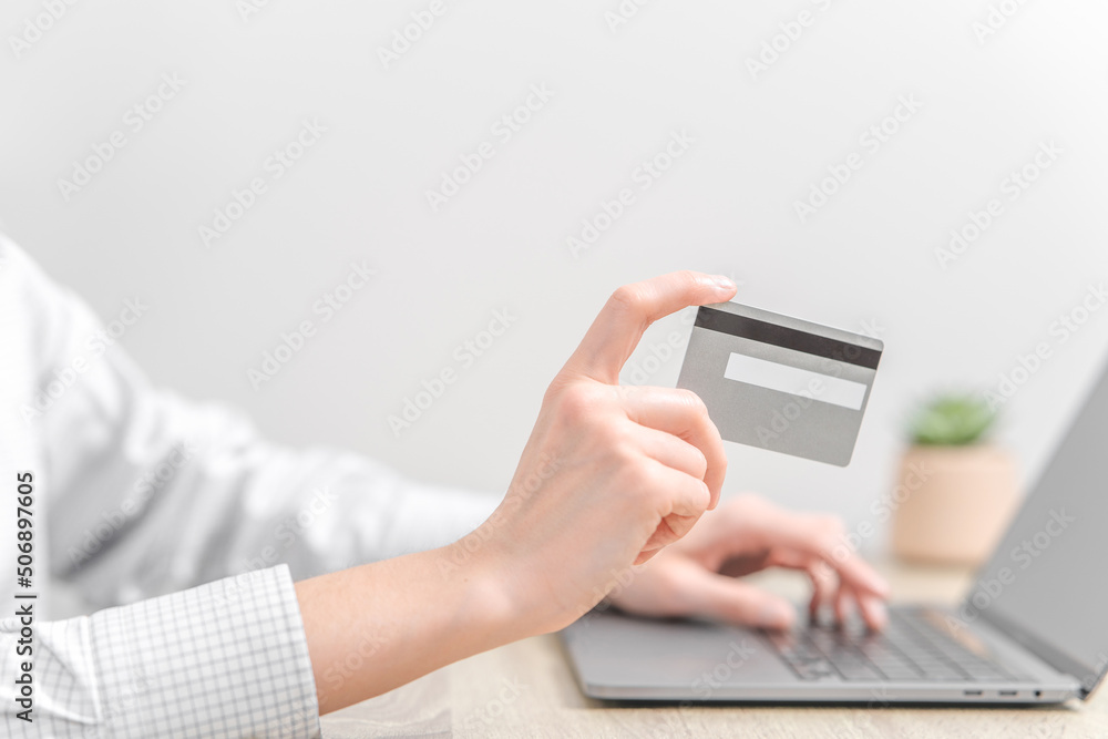 Woman using laptop and holding credit card in hands. Woman using laptop and holding credit card in hands.