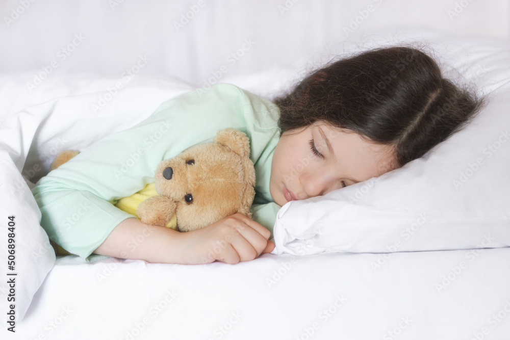 Sad girl with a toy bear lies on the bed Sad girl with a toy bear lies on the bed