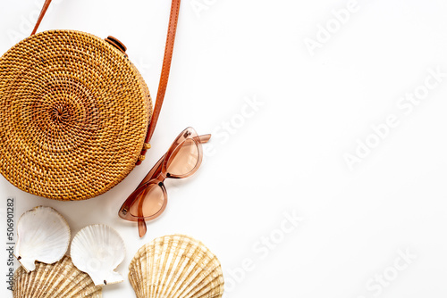 Summer rattan bag with beach accessories. Beach flatlay background