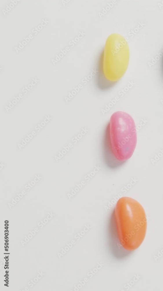 Video of overhead view of rows of multi coloured sweets with copy space over white background Video of overhead view of rows of multi coloured sweets with copy space over white background