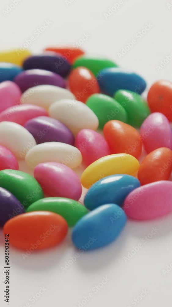 Video of close up of multi coloured sweets forming circle over white background Video of close up of multi coloured sweets forming circle over white background