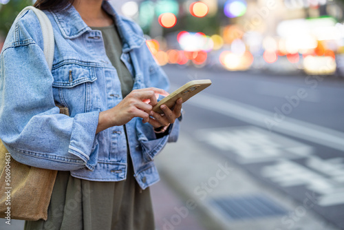 Woman hold with mobile phone in the city