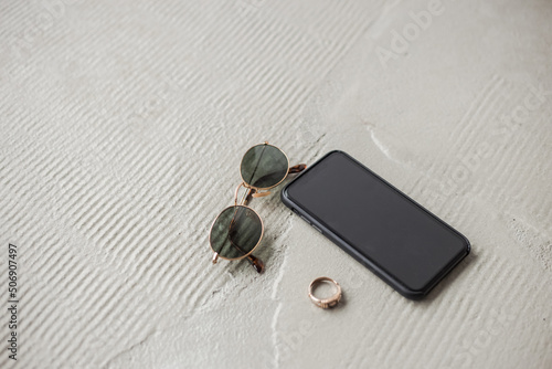 Phone and glasses lying on the white concrete floor