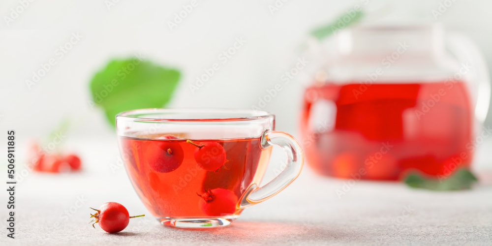 Hawthorn tea in a glass teapot and a cup on the table. Vitamin health drink. Hawthorn tea in a glass teapot and a cup on the table. Vitamin health drink.