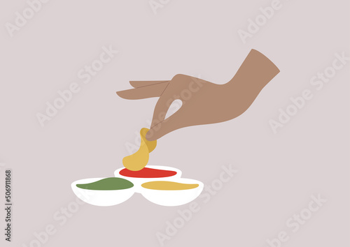 A hand dipping a potato chip into a tomato sauce