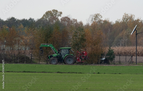 Pultusk, Poland - October 29, 2021: Tractor with a machine for loosening the soil. Agricultural machinery with a tractor in the autumn season in the countryside. photo