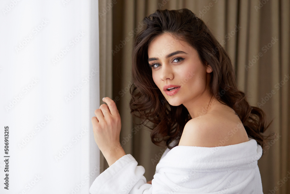Profile portrait of a beautiful brunette young woman with hairstyle in a white bathrobe. Profile portrait of a beautiful brunette young woman with hairstyle in a white bathrobe.