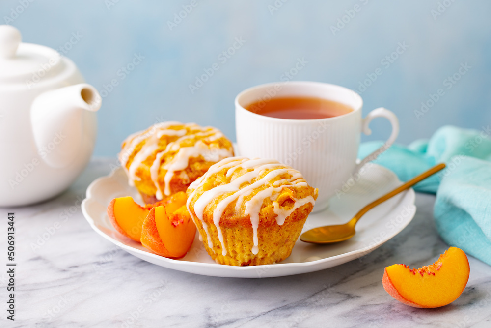 Peach cupcakes, muffins with cup of tea. Marble table. Close up. Peach cupcakes, muffins with cup of tea. Marble table. Close up.