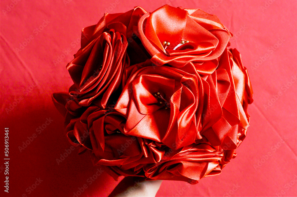 Naklejka premium Beautiful artificial bouquet of satin red roses